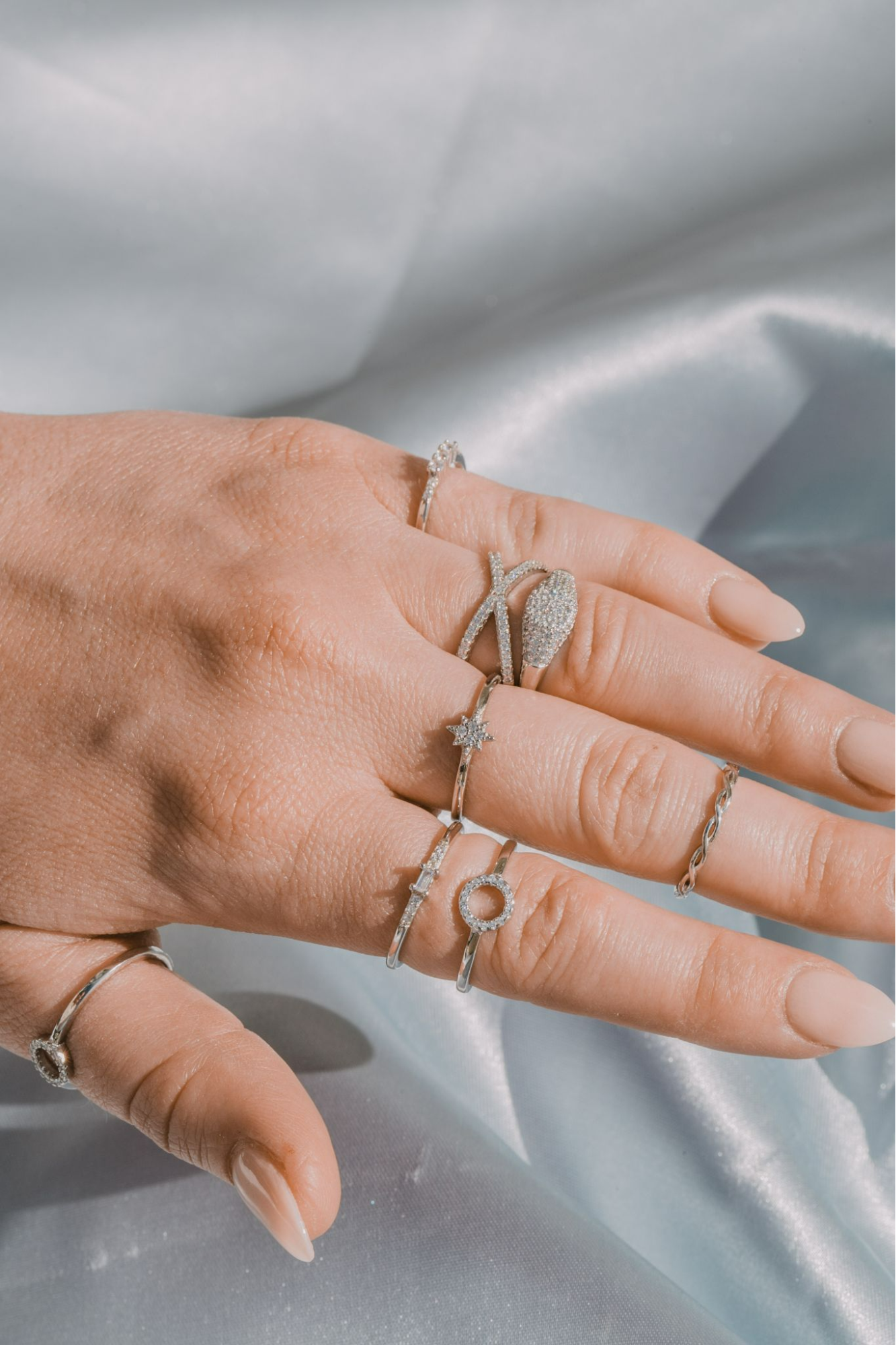 A closeup of a woman's hand wearing sterling silver stacking rings