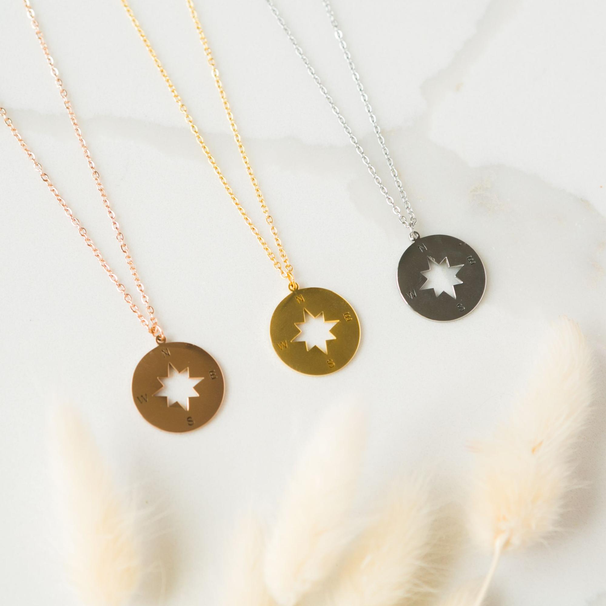 Three compass shaped medallion necklaces in rose gold, yellow gold and white gold