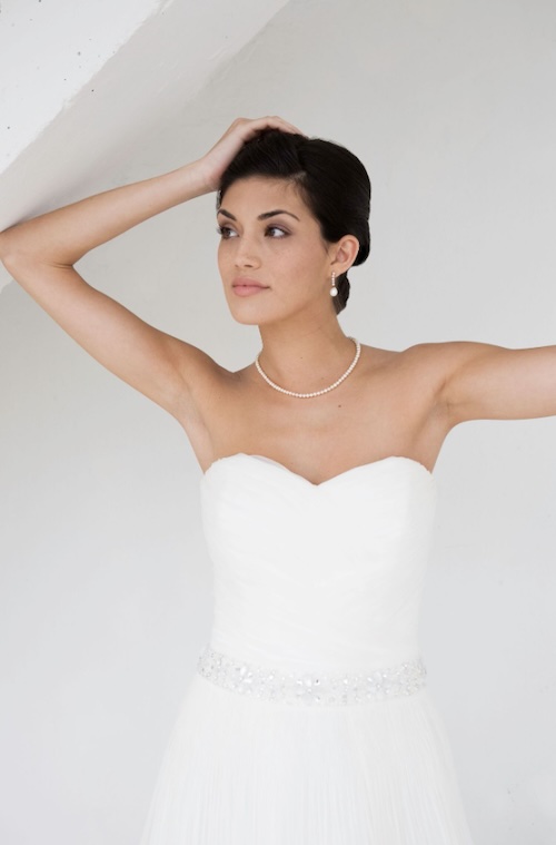 bride in strapless gown wearing pearl necklace and earrings
